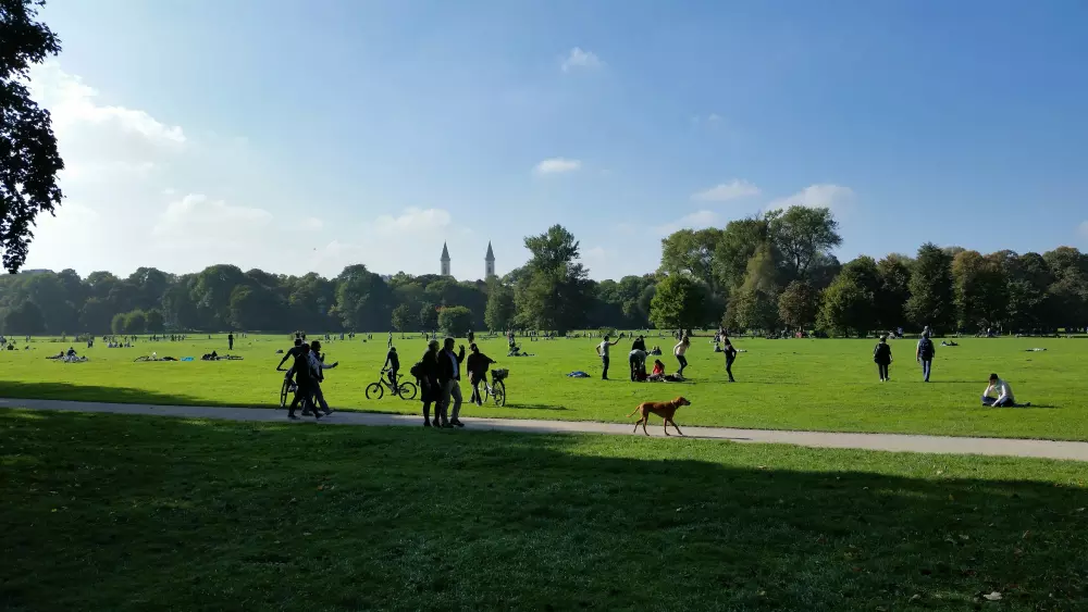 Eine Gruppe von Menschen steht auf einer üppig grünen Wiese.