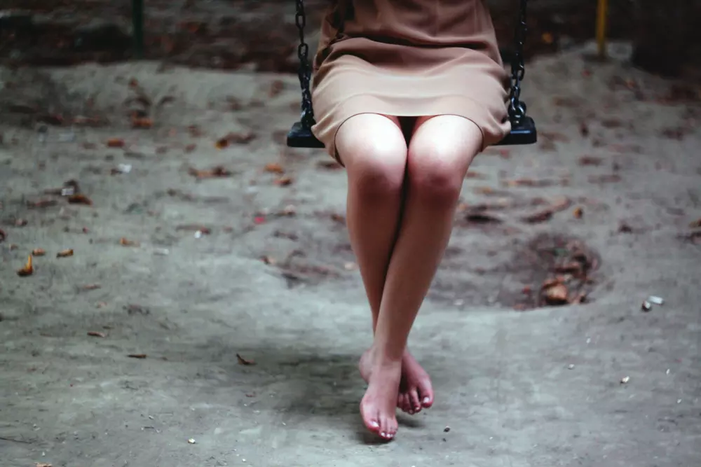 Eine Frau sitzt auf einer Schaukel in einem Park